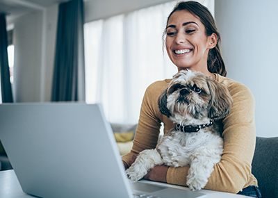 A woman opening a bank acount online with her dog